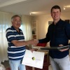 Voorzitter Chris Gispen krijgt laptop uit handen van Tijs de Jong van GroenWest